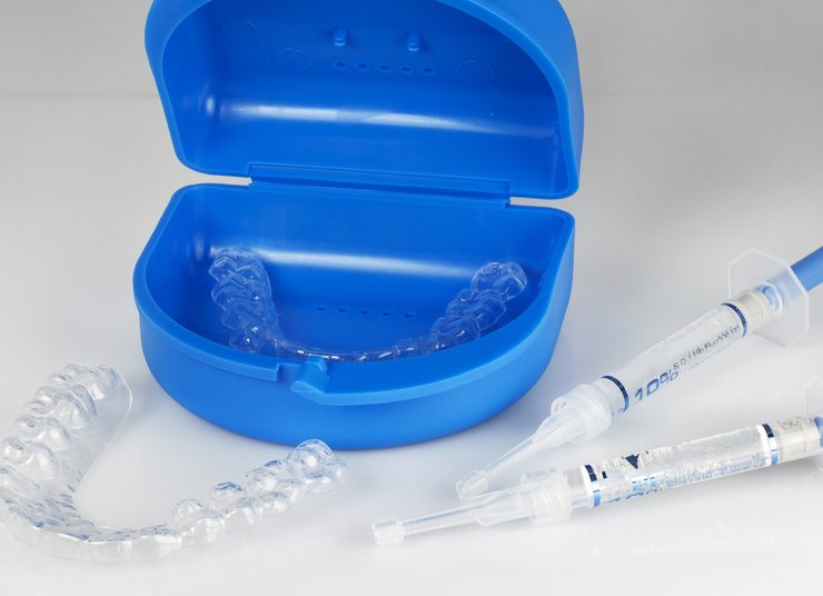 Custom whitening trays in a blue case with syringes of whitening gel